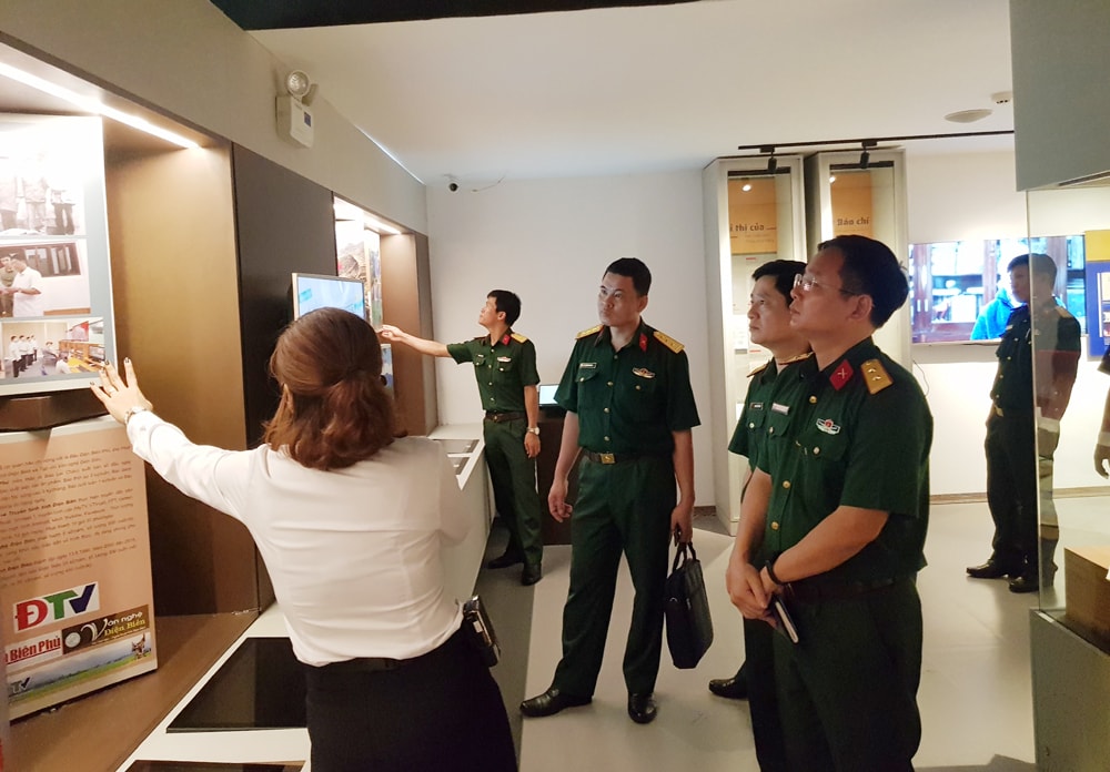 Lãnh đạo Bảo làng Lịch sử Quân sự Việt Nam nghe giới thiệu về các hiện vật tại Bảo tàng Báo chí Việt Nam. Ảnh Lê Tâm