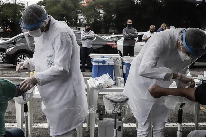 Nhân viên y tế lấy mẫu xét nghiệm COVID-19 tại Sao Paolo, Brazil. Ảnh: THX/TTXVN