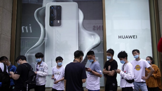 Mọi người đứng xếp hàng trước cửa hàng của Huawei ở Thượng Hải. Ảnh: Reuters