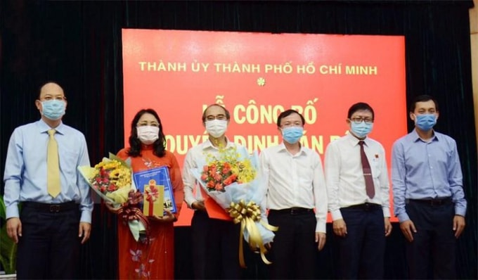 Hai ông bà Phan Văn Thoại và Nguyễn Thị Kim Chi (cầm hoa) nhận quyết định nghỉ hưu trước tuổi. Ảnh thanhuytphcm.vn