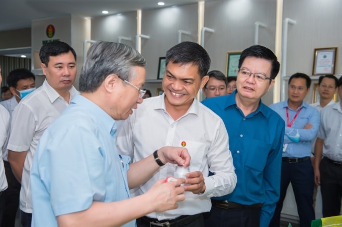Tổng Giám đốc PVCFC Văn Tiến Thanh báo cáo với đồng chí Trần Quốc Vượng về tình hình đưa sản phẩm tới bà con
