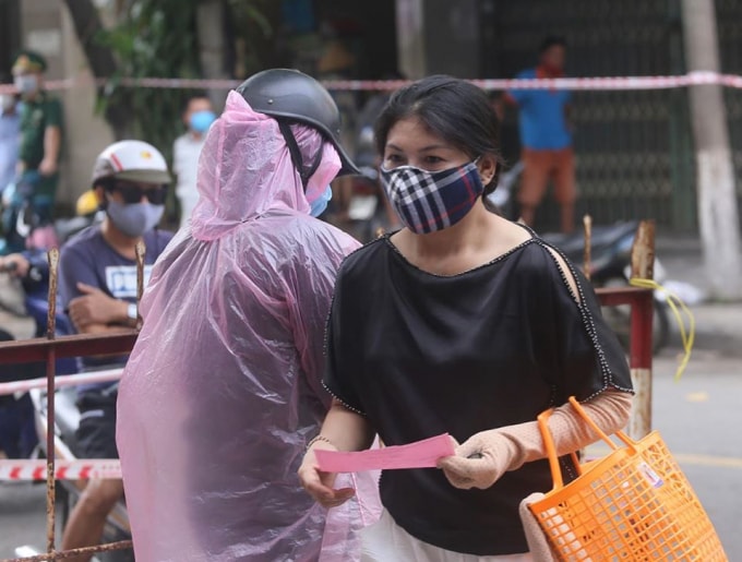 Nữa tháng, mỗi gia đình chỉ có được 5 phiếu đi chợ (ảnh TL).