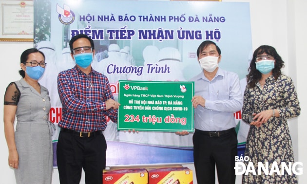 Ông Nguyễn Đức Nam, Chủ tịch Hội Nhà báo thành phố Đà Nẵng (thứ 2, từ phải sang), tiếp nhận 234 triệu đồng từ đại diện Ngân hàng VPBank khu vực miền Trung. Ảnh: Đắc Mạnh