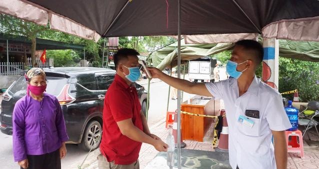 Người dân đi từ Lạng Sơn vào địa phận huyện Tiên Yên đều được đo thân nhiệt, kiểm tra y tế, phòng chống dịch bệnh Covid-19 tại Quảng Ninh. Ảnh: Thái Bình.