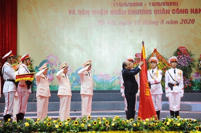 Thủ tướng Nguyễn Xuân Phúc gắn Huân chương Quân công hạng Nhất lên Cờ truyền thống của lực lượng CAND. (Ảnh BCA)