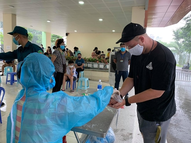 Hướng dẫn người dân đeo khẩu trang, rửa tay sát khuẩn đúng quy định. Ảnh: TL.