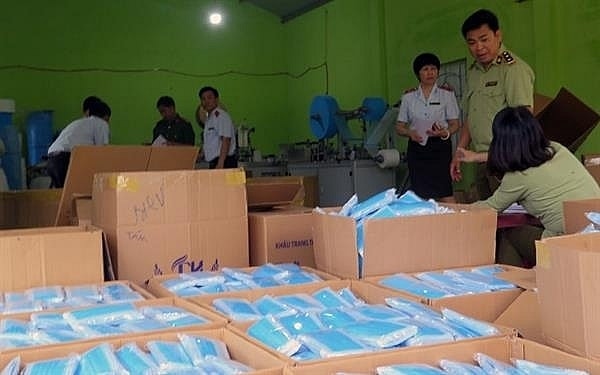 Lực lượng chức năng kiểm tra một cơ sở sản xuất khẩu trang. Ảnh minh họa