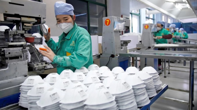 Công nhân làm khẩu trang tại một nhà máy ở Thượng Hải. Ảnh: Reuters