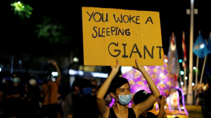 Một người biểu tình cầm biểu ngữ tại một cuộc biểu tình ở Bangkok. Ảnh: Reuters