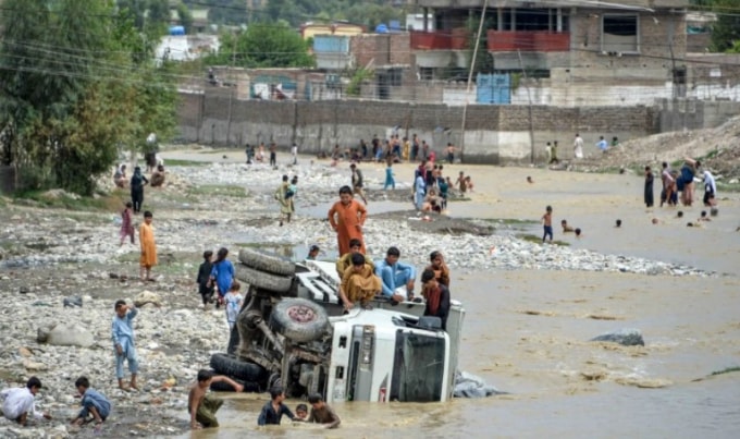 Một phương tiện bị lật sau trận lũ quét ở Jalalabad - Ảnh: AFP