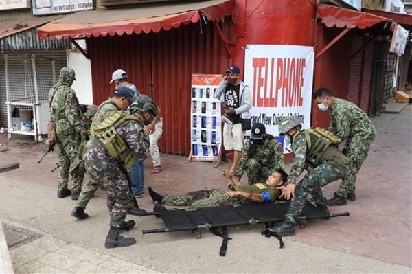 Các binh sĩ Philippines đưa người bị thương ra khỏi hiện trường vụ nổ. Nguồn: TTXVN
