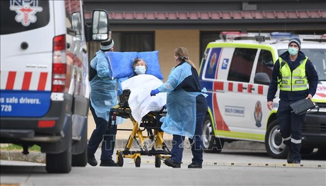 Nhân viên y tế chuyển bệnh nhân mắc COVID-19 lên xe cứu thương tại ngoại ô thành phố Melbourne, bang Victoria, Australia ngày 27/7. Ảnh: AFP/TTXVN.