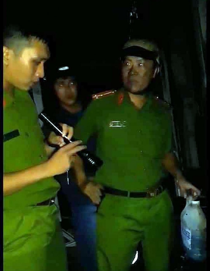 Thượng úy Nguyễn Văn Hùng thu giữ can xăng. Ảnh: TL.