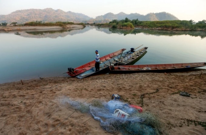 Một ngư dân trên dòng sông Mekong đang cạn khô - Ảnh: Reuters