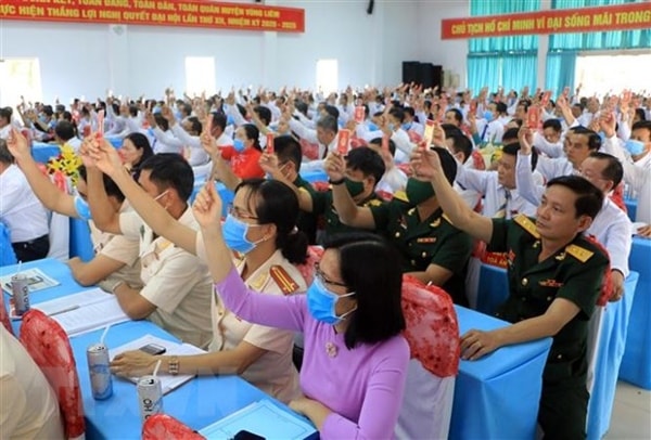 Các đại biểu biểu quyết thông qua Nghị quyết Đại hội Đảng bộ huyện Vũng Liêm, Vĩnh Long. Ảnh: TTXVN