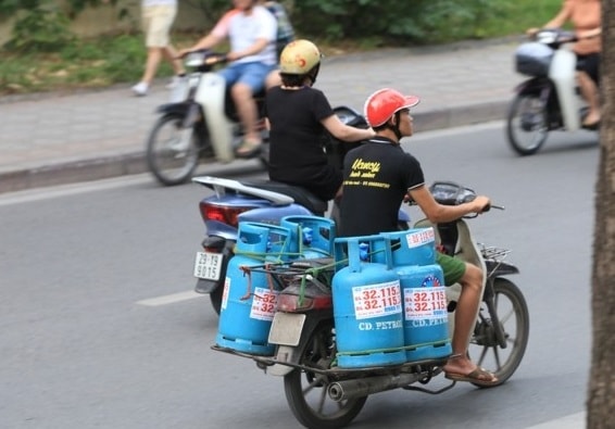 Những chiếc xe máy cũ được tận dụng để gas phía sau không khác gì những quả bom di động trên đường. Ảnh: TL