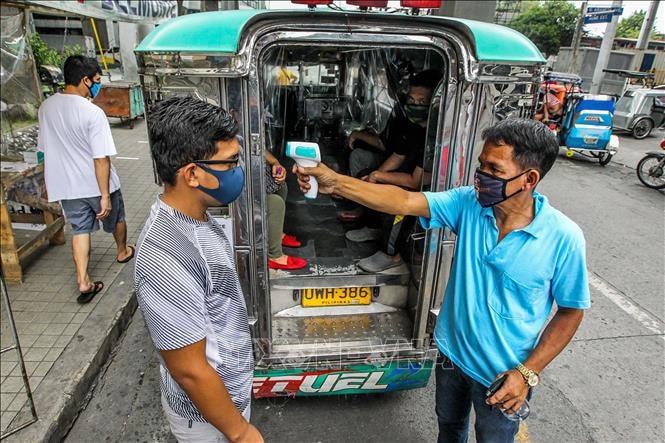 Kiểm tra thân nhiệt nhằm ngăn chặn sự lây lan của dịch COVID-19 tại Manila, Philippines. Ảnh: THX/TTXVN.