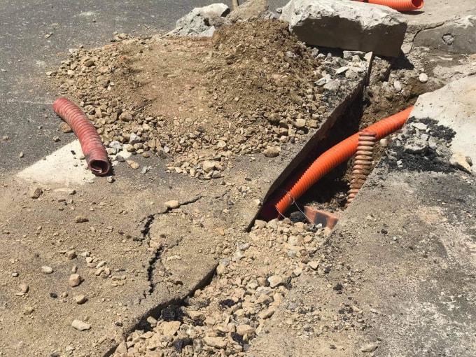 Đường thảm nhựa mới hoàn thành bị cắt để kéo dây điện ngầm