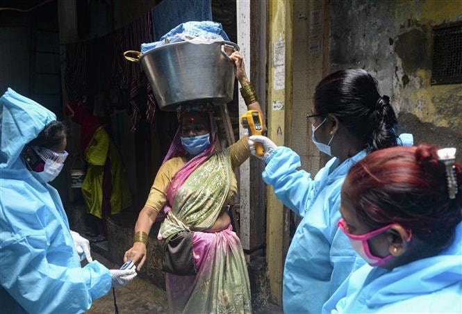 Kiểm tra thân nhiệt phòng lây nhiễm COVID-19 tại Mumbai, Ấn Độ. Ảnh: AFP/TTXVN.