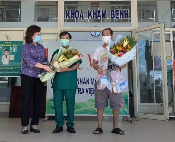 BN936 (phải) và đại diện thầy thuốc của Trung tâm Y tế Hoà Vang được tặng hoa nhân BN Covid-19 cuối cùng của Đà Nẵng được công bố khỏi bệnh.