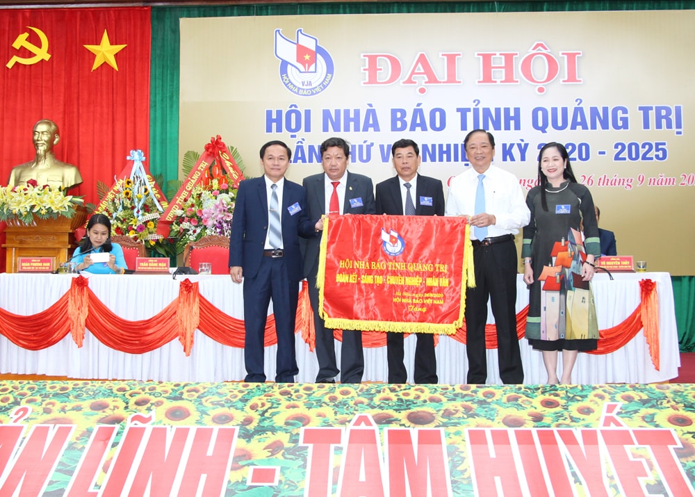 Phó Chủ tịch Hội Nhà báo Việt Nam Mai Đức Lộc tặng Hội Nhà báo tỉnh Quảng Trị bức trướng mang dòng chữ “Hội Nhà báo tỉnh Quảng Trị đoàn kết, sáng tạo, chuyên nghiệp, nhân văn”. Ảnh: Thành Dũng