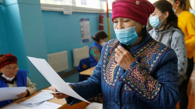 Một cử tri nghiên cứu lá phiếu trong cuộc bầu cử quốc hội ở làng Besh-Kungey, Kyrgyzstan, vào ngày 4 tháng 10. Ảnh: Reuters