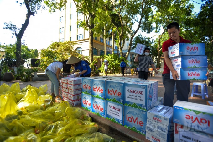 Các thùng nước lọc được các thanh niên tình nguyện chuyển vào tập kết.