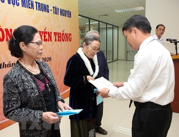 Tổng giám đốc TTXVN Nguyễn Đức Lợi trao tặng sổ tiết kiệm cho thân nhân, gia quyến 17 liệt sỹ, nhà báo của TTXVN đã hy sinh trên các chiến trường khu vực miền Trung-Tây Nguyên tại buổi lễ. (Ảnh: Trần Lê Lâm/TTXVN)