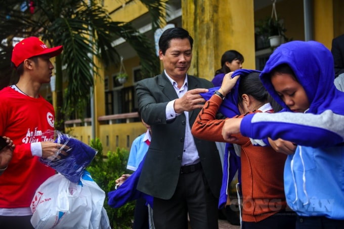 Thầy Đoàn Minh Thắng, Phó Giám đốc Sở GD&ĐT tỉnh Thừa Thiên Huế cùng với báo Nhà báo và Công luận trao áo ấm cho học sinh bị ngập lũ.
