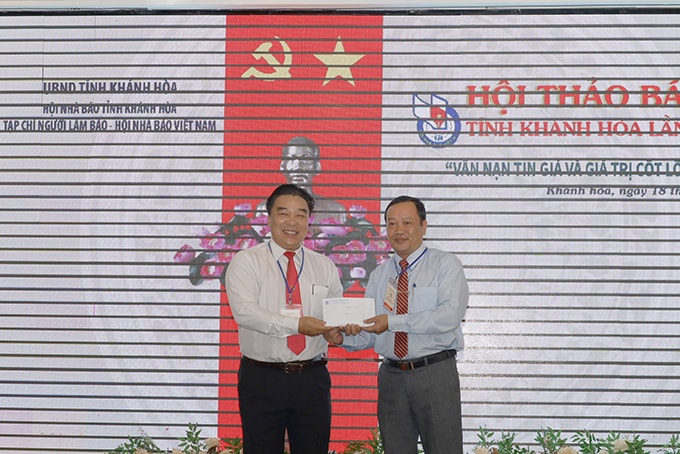 Ông Đoàn Minh Long - Chủ tịch Hội Nhà báo tỉnh Khánh Hòa (bên trái) trao số tiền các đại biểu quyên góp ủng hộ đồng bào miền Trung tới đại diện Ủy ban MTTQ Việt Nam tỉnh Khánh Hòa. Ảnh: N.T