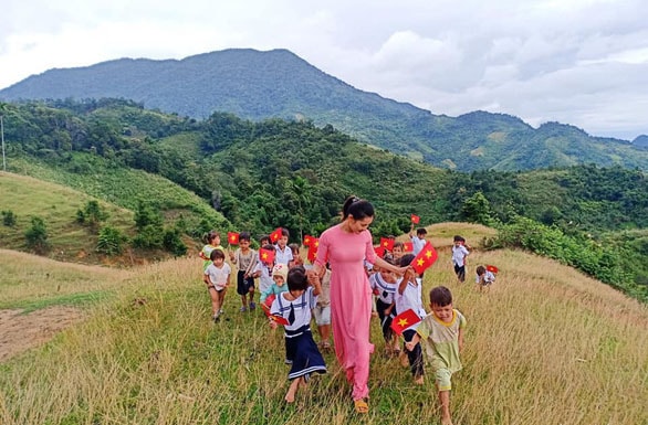 Cô trò cùng nhau chụp hình trên bãi đất trống nằm cheo leo trên đỉnh Ngọc Linh - Ảnh: Trà Thị Thu