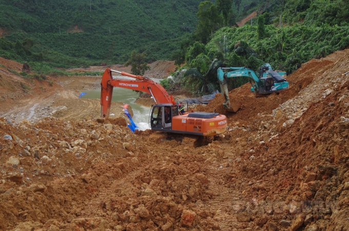 Các lực lượng tìm kiếm nạn nhân quoanh khu vực chiếc xe tải bị vùi lấp.