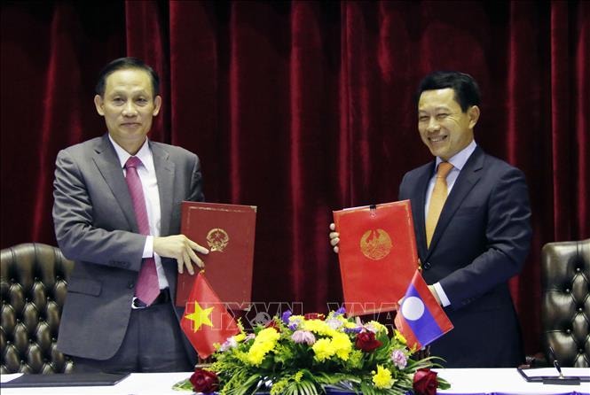Bộ trưởng Saleumxay Kommasith và Thứ trưởng Lê Hoài Trung trao đổi biên bản hợp tác về biên giới. Ảnh: TTXVN