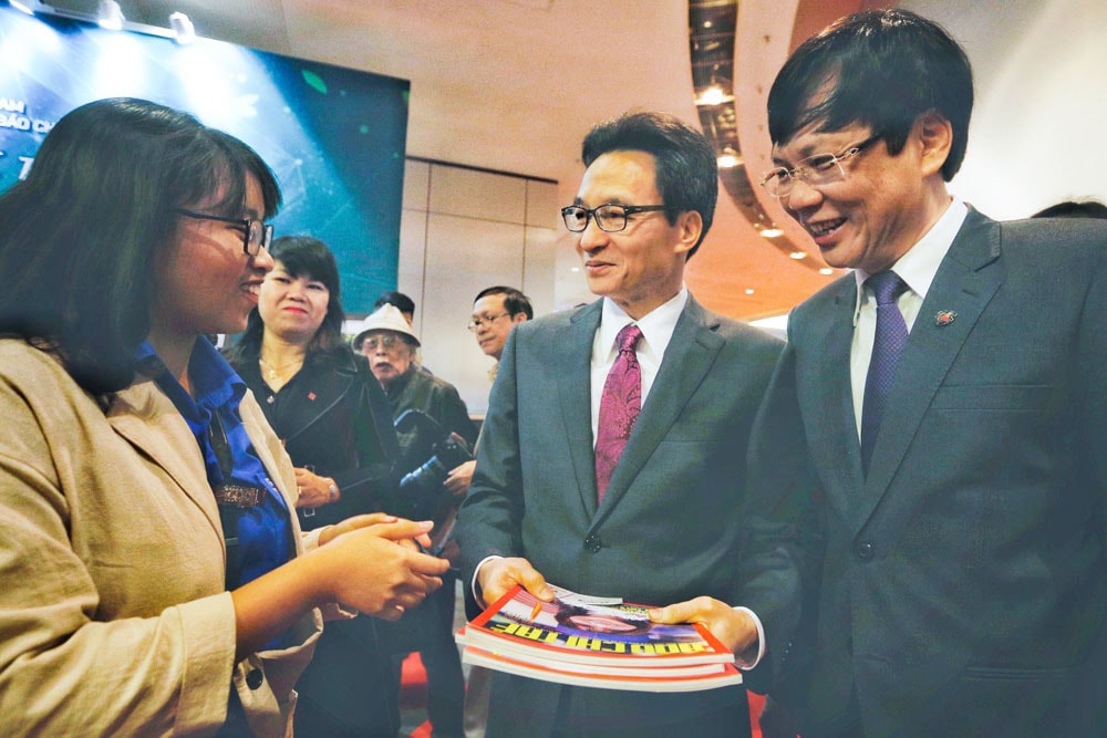 Phó Thủ tướng Vũ Đức Đam và nhà báo Hồ Quang Lợi - Phó Chủ tịch Thường trực Hội Nhà báo Việt Nam nghe giới thiệu về Đặc san Báo chí Trẻ.