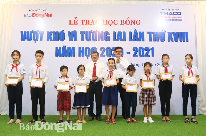 Tổng biên tập Báo Đồng Nai Nguyễn Tôn Hoàn và ông Nguyễn Một, Giám đốc truyền thông Công ty cổ phần Trường Hải trao học bổng cho các em học sinh. ảnh: Huy Anh