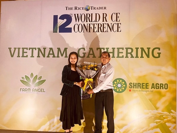 Tác giả gạo thơm ST25 - kỹ sư Hồ Quang Cua (phải) nhận hoa chúc mừng từ đại diện Ban tổ chức The Rice Trader
