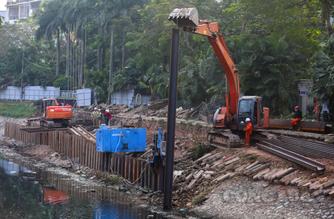 Các máy xúc được huy động để ép cọc chống sạt lở, sau đó nhà thầu sẽ chôn ống thu gom nước thải và thi công trải bê tông, làm hố ga.