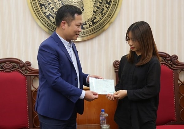 Quyền Tổng Giám đốc Cổng TTĐT Chính phủ Nguyễn Hồng Sâm thăm hỏi, động viên và trao tặng sổ tiết kiệm cho con gái cả của nhà báo - liệt sĩ Phạm Văn Hướng. Ảnh: VGP