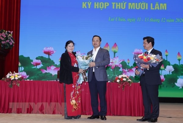 Chủ tịch UBND tỉnh Lai Châu Trần Tiến Dũng tặng hoa chúc mừng bà Giàng Páo Mỷ. Ảnh: TTXVN