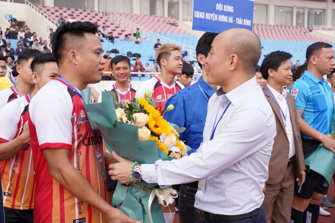 Ông Phạm Quốc Cường - Tổng Thư ký Tòa soạn Pháp luật Plus (Báo Pháp luật Việt Nam), Trưởng Ban tổ chức tặng hoa chúc mừng các đội. Ảnh: phapluatplus.vn