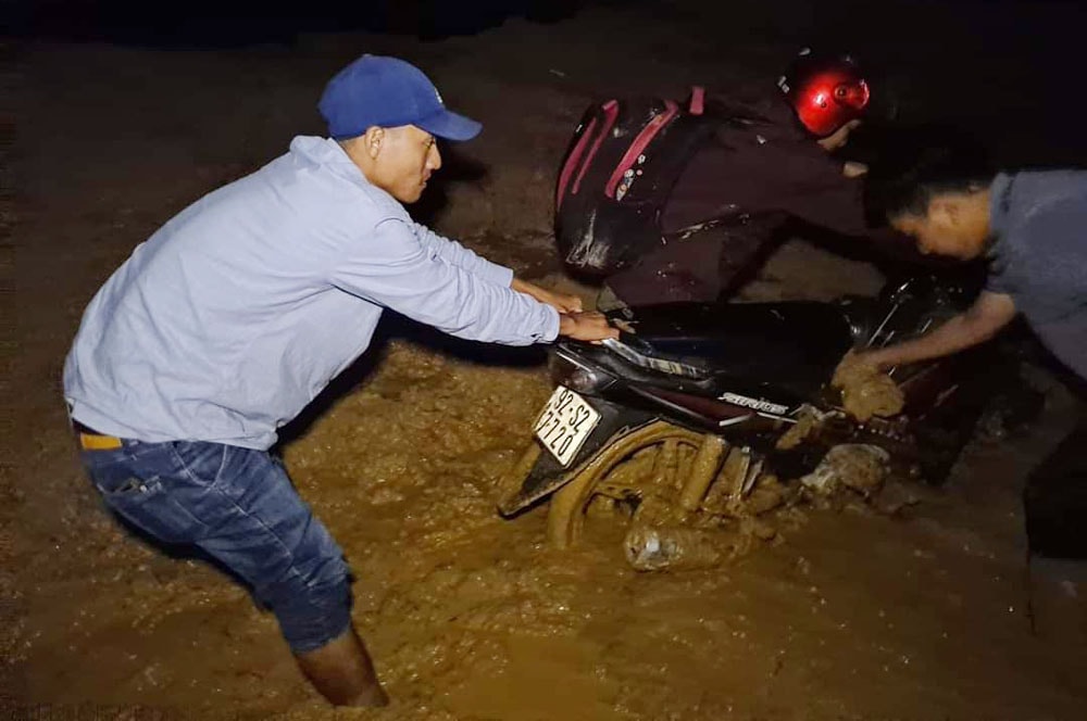 Nhà báo Võ Ngọc Thạnh kéo xe máy của một người dân ra khỏi bùn lầy tại xã Phước Lộc, huyện Phước Sơn, tỉnh Quảng Nam.