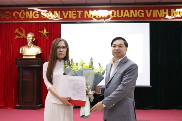 Ông Lê Mạnh Hùng chúc mừng và trao quyết định cho bà Vũ Diệu Thu. Ảnh: dangcongsan.vn