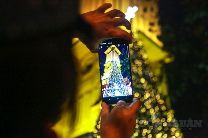 Nhiều người dân tranh thủ ghi lại những khoảng khắc cây thông Noel với ánh đèn lung linh chỉ 1 năm có 1 lần ở nhà thờ.