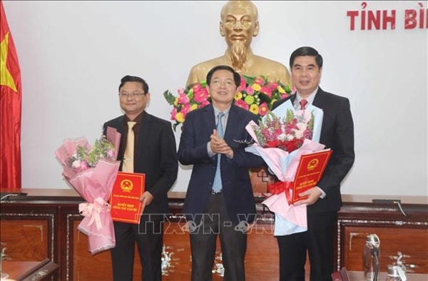 Ông Hồ Quốc Dũng, Bí thư Tỉnh ủy, Chủ tịch HĐND tỉnh Bình Định trao quyết định và tặng hoa chúc mừng các ông Lâm Hải Giang (phải) và Nguyễn Tự Công Hoàng (trái). Ảnh: TTXVN