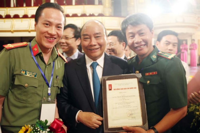 Nhà báo Đặng Việt Hưng (bên trái) chụp ảnh cùng Thủ tướng Nguyễn Xuân Phúc tại lễ trao giải Báo chí Quốc gia năm 2019.
