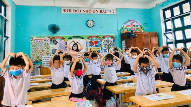 Học sinh tiểu học hân hoan đi học trở lại (ảnh TL).