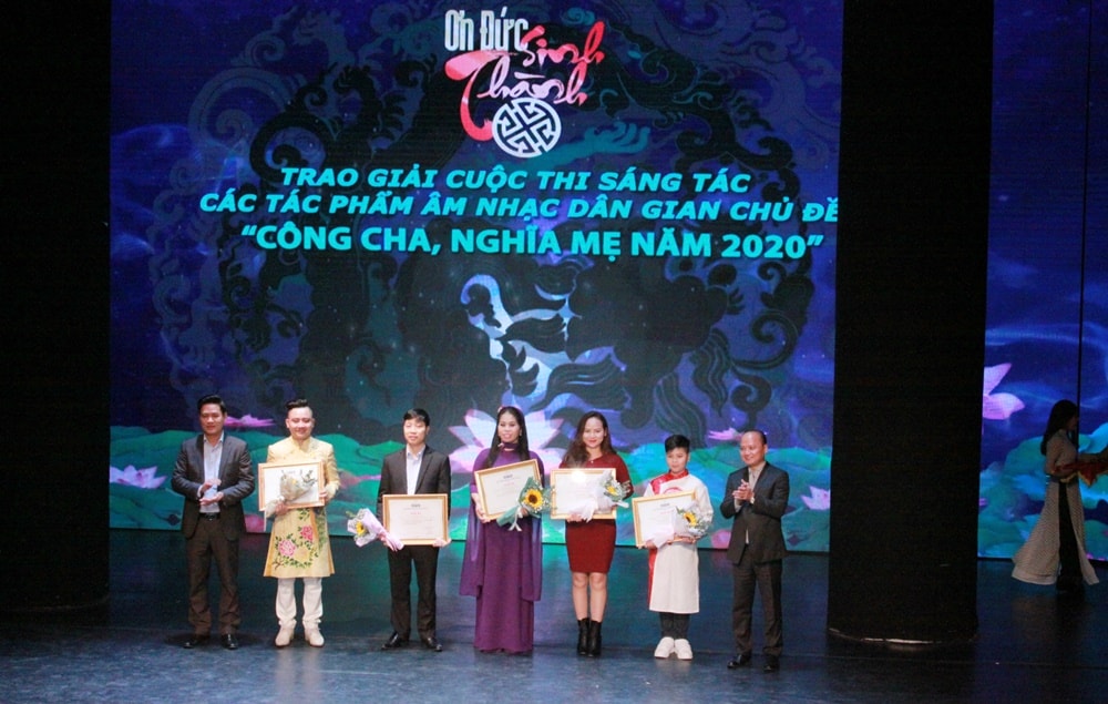 Ban tổ chức trao giải thưởng cho các tác giả có tác phẩm tham dự cuộc thi sáng tác và biểu diễn các tác phẩm âm nhạc dân gian chủ đề Công cha, Nghĩa mẹ. Ảnh: Lê Tâm