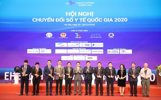 Đồng chí Vũ Đức Đam, Phó Thủ tướng Chính phủ và đồng chí Nguyễn Thanh Long, Bộ trưởng Bộ Y tế trao cúp vinh danh đơn vị tiên phong trong chuyển đổi số y tế năm 2020.