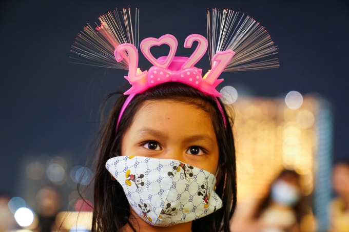 Một cô bé đeo bờm đón năm 2021 với khẩu trang ở Bangkok, Thái Lan. Ảnh: Reuters