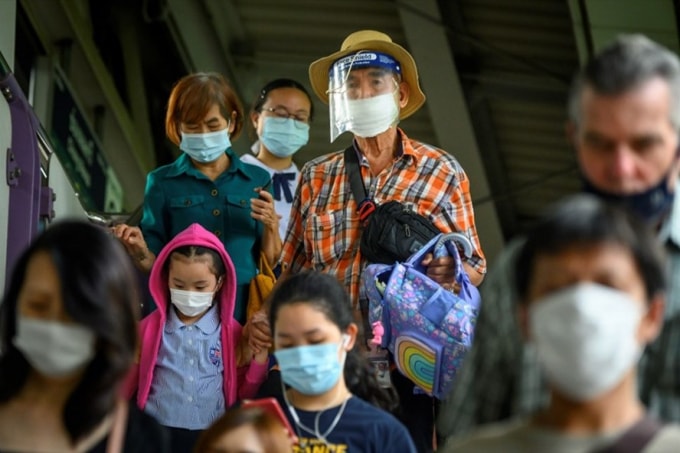 Hành khách đeo khẩu trang bước ra khỏi ga tàu ở Bangkok. Ảnh: TL